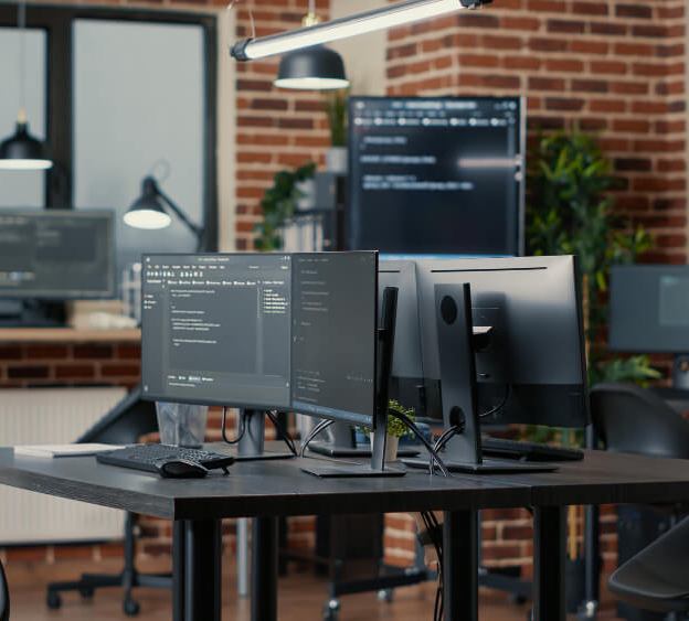 Modern developer workspace with multiple monitors displaying code at Sydney's Web Design Agency, creating responsive and high-performance websites.